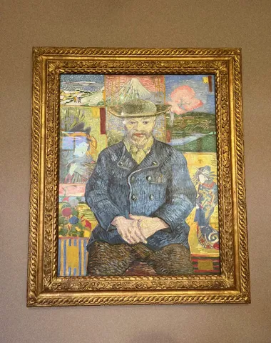 Portrait of Père Tanguy: a framed painting of a seated man in a blue jacket and hat, in an ornate gold frame